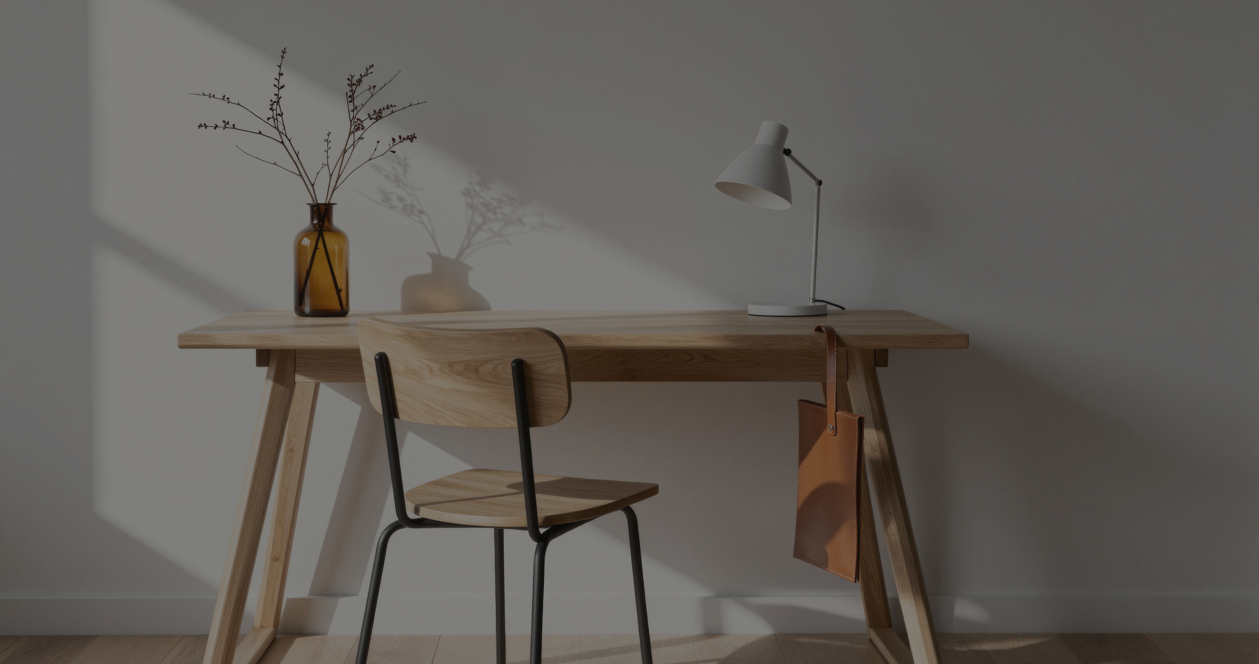 Ein Bild eines modernen Schreibtisches mit einer Lampe und einem Stuhl in einem weißen Raum.